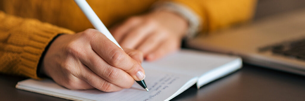 Can I take my child on holiday if I am not the resident parent? Picture of a person writing a holiday arrangements plan.