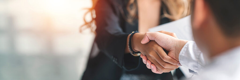 Can I take my child on holiday if I am not the resident parent? Picture of two parents shaking hands when making an arrangement for their children.