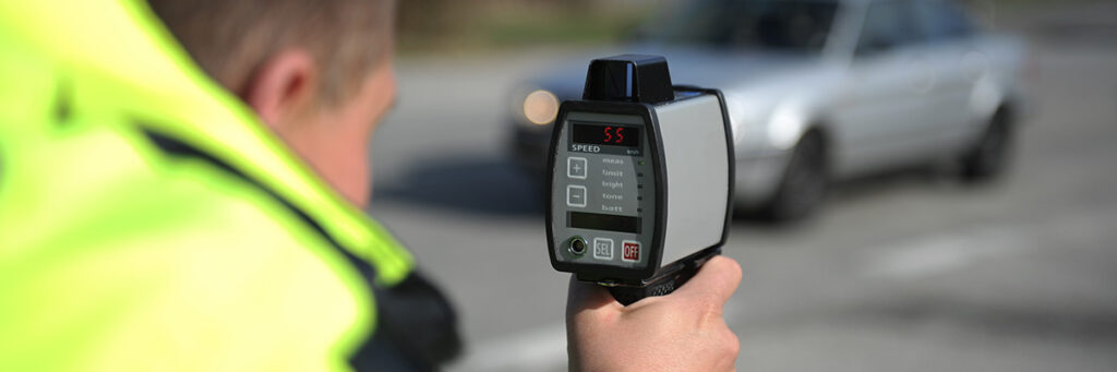 Speeding Offence Solicitors - Picture of a police officer checking the speed of passing vehicles.