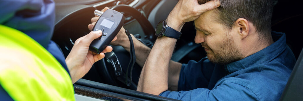 Drink Driving Offence Solicitors - Picture of a police officer requesting a breathalyser test from a motorist.